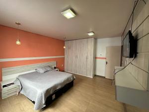 a bedroom with a bed and a flat screen tv at Pousada Residencial - PVH in Porto Velho