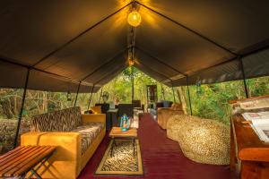 a large tent with couches and a table in it at Mahoora - Wilpattu by Eco Team in Wilpattu