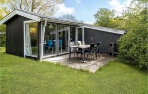 a black shed with a table and chairs on a deck at 3 Bedroom Cozy Home In Ask 