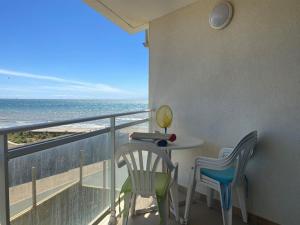 een balkon met een tafel en stoelen en de oceaan bij Appartement Longeville-sur-Mer, 2 pièces, 4 personnes - FR-1-336-69 in Longeville-sur-Mer