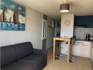 een woonkamer met een bank en een keuken bij Appartement Longeville-sur-Mer, 2 pièces, 4 personnes - FR-1-336-69 in Longeville-sur-Mer