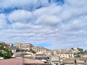 un gruppo di edifici in una città sotto un cielo nuvoloso di B & B Domus San PietRo a Rossano