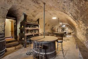 - une salle de dégustation de vin avec table et tabourets dans l'établissement Villa Sibilla Il Giardino Di Sibilla With Pool, à Monte San Lorenzo