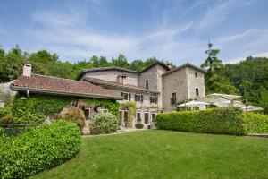 uma grande casa de pedra com um quintal verde em Villa Sibilla Il Giardino Di Sibilla With Pool em Monte San Lorenzo