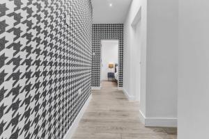 un pasillo con azulejos blancos y negros en la pared en We Stay Baxter Gate 3 Bedroom Apartment en Loughborough