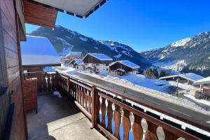 a balcony with a view of a snow covered mountain at Chalet Letach - 'Great Bike Park Access' relax around the fire pit, mountain retreat in Châtel