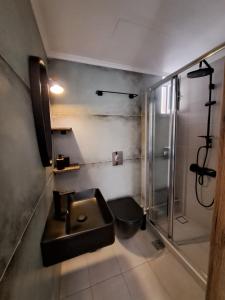 a bathroom with a sink and a shower at Poppy Beloni in Chania Town