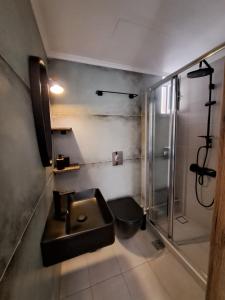 a bathroom with a sink and a shower at Poppy Beloni in Chania