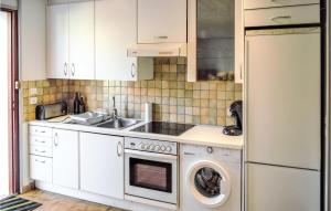 uma cozinha com armários brancos e uma máquina de lavar e secar roupa em Beautiful Apartment In Saint-pe-sur-nivelle With Kitchen em Saint-Pée-sur-Nivelle