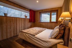 a bedroom with a bed in a room with a window at La grange au ruisseau in Bellecombe-en-Beauges