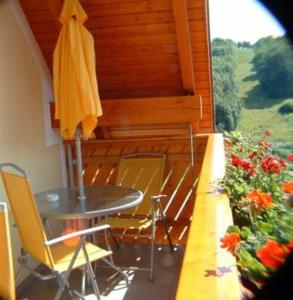 eine Terrasse mit einem Tisch, Stühlen und einem Sonnenschirm in der Unterkunft Apfelhof FLIEDER in Kukmirn