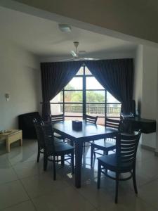 a dining room with a table and chairs and a window at Marina Heights Hotel Residences in Lumut