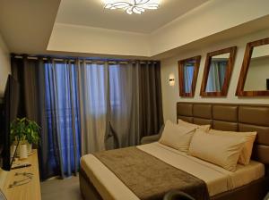 um quarto com uma cama com cortinas azuis em Skycourt Suites at Azure North Pampanga Condominium em San Fernando