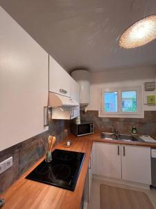 a kitchen with white cabinets and a stove top oven at Grand appartement a 300M de la plage in Sainte-Maxime