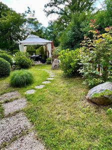 einen Garten mit einem Tisch und einem Pavillon in der Unterkunft Pension Marco in Trendelburg