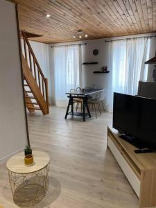 a living room with a television and a dining table at L'appart de la liberté in Millau