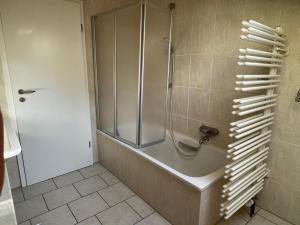 um chuveiro com uma porta de vidro na casa de banho em Pension Marco em Trendelburg