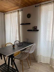 a table and chairs in a room with curtains at L'appart de la liberté in Millau
