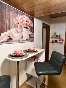 a room with a table and two chairs and a painting at Pension Marco in Trendelburg
