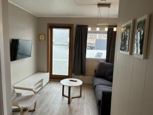 una pequeña sala de estar con sofá y mesa. en The Painter's house with view and balcony, en Siglufjörður