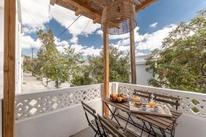 a table and chairs on a balcony with an umbrella at The Locals in Káto Potamiá