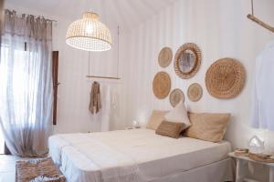 a white bedroom with a bed and a chandelier at I trulli di Kate in Monopoli
