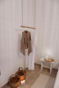 a coat hanging on a wall next to a table at I trulli di Kate in Monopoli +50 photos