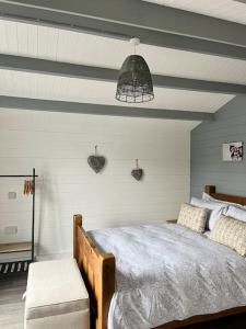 a bedroom with a wooden bed and a ceiling at Blackbrook Lodge Cabin in Turnditch