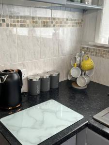 a kitchen counter top with cups and a tea kettle at Blackbrook Lodge Cabin in Turnditch