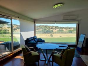 a living room with a table and chairs and a large window at Villa Infinity in Cuba