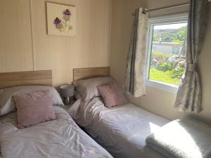 two twin beds in a room with a window at Summer Breeze in Heast