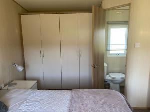 a bedroom with a bed and a bathroom with a toilet at Summer Breeze in Heast