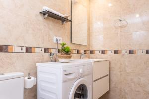 een badkamer met een wasmachine en een wastafel bij RVApartaments Els Salats in L'Estartit