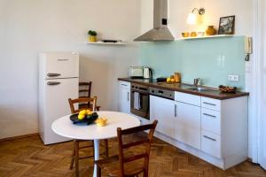 a kitchen with a table and a white refrigerator at Stilvolles Apartment im Zentrum in Graz