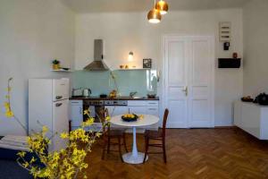 uma cozinha com uma mesa e um frigorífico branco em Stilvolles Apartment im Zentrum em Graz
