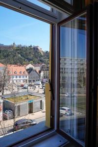 una ventana abierta con vistas a una calle de la ciudad en Stilvolles Apartment im Zentrum en Graz