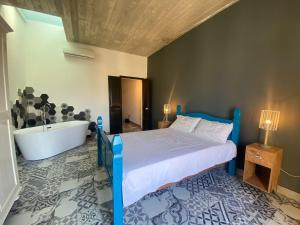 a bedroom with a blue bed and a bath tub at Sliema Distant Seaview Penthouse in Sliema