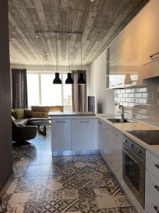 a kitchen with white cabinets and a living room at Sliema Distant Seaview Penthouse in Sliema