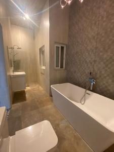 a bathroom with a white tub and a toilet at Sliema Distant Seaview Penthouse in Sliema