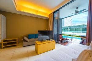 ein Schlafzimmer mit einem Bett, einem TV und einem Sofa in der Unterkunft Greystone 99 Suites in Malakka