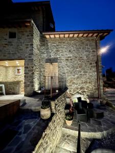 un edificio con una pared de piedra y un patio en Villa Borgo Soale, en Reggello