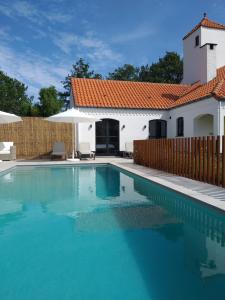 a swimming pool in front of a house at Landhuys Odette in Retie