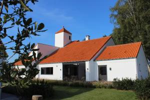 biały budynek z pomarańczowym dachem w obiekcie Landhuys Odette w mieście Retie