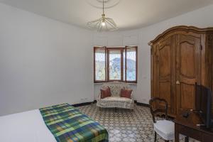 a bedroom with a bed and a chair and a dresser at A Few Steps from the Sea by Wonderful Italy in Recco