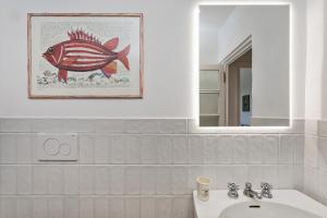 a bathroom with a picture of a fish on the wall at A Few Steps from the Sea by Wonderful Italy in Recco