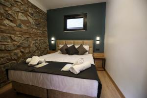 a bedroom with a large bed with a stone wall at Mia Mia Suites in Istanbul