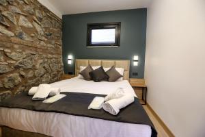 a bedroom with a large bed with a stone wall at Mia Mia Suites in Istanbul