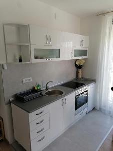 a white kitchen with a sink and a stove at Apartman Savic in Vrnjačka Banja