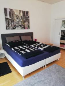 a bed in a bedroom with a painting on the wall at Appartement mit Terrasse in Metterzimmern +23 photos