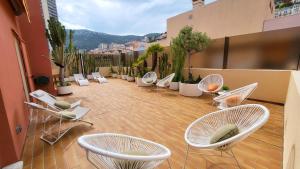 a patio with white chairs and a bunch of plants at PENTHOUSE MAJESTIC, MC, Bnbrickeys in Monte Carlo